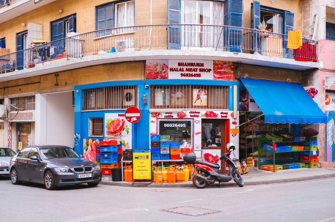 services-01 Colorful urban street scene featuring Shahrukh Halal Meat Shop with vehicles and vibrant signage.